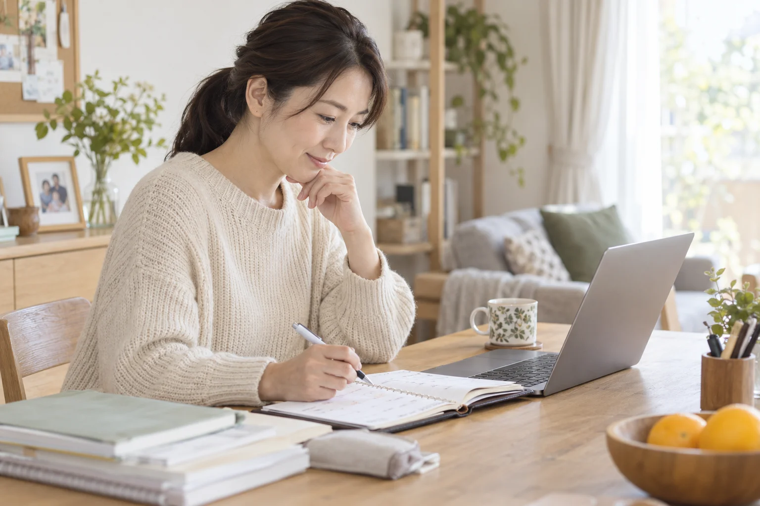 パソコンと手帳で受験の予定を確認する保護者